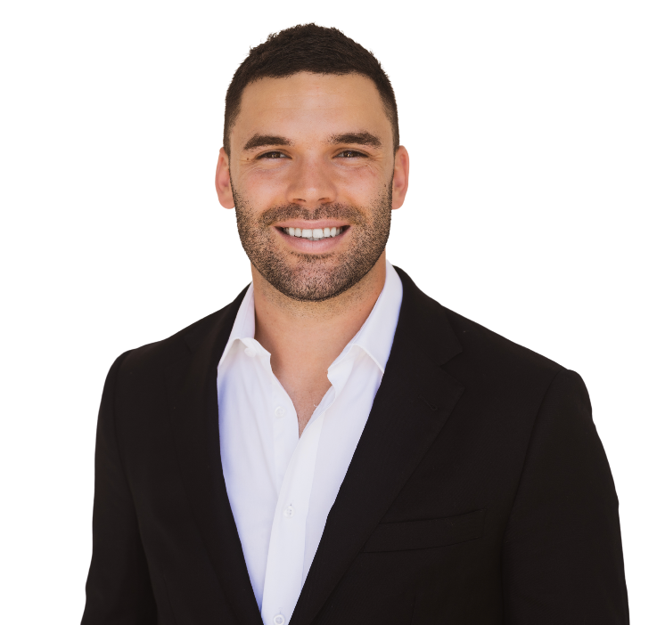 Tyler Cornish in a blue suit and white shirt smiles for the camera