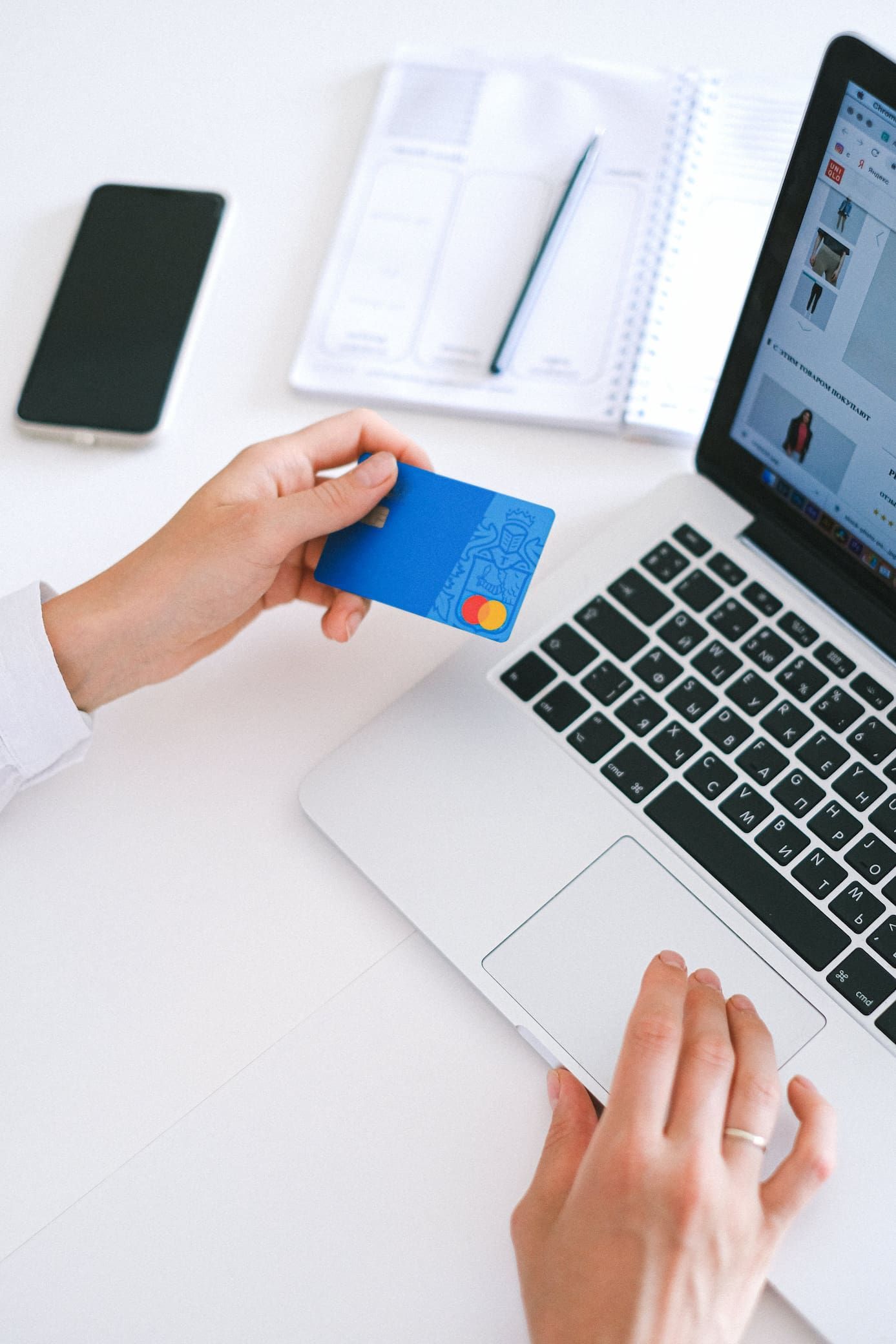 a person holding a credit card in front of a laptop - asset finance