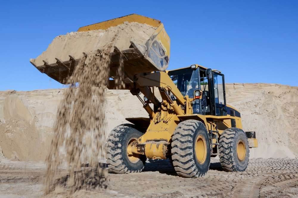 A Bulldozer Is Pouring Sand Into A Pile — HKL Landscape Supplies in Nabiac, NSW 