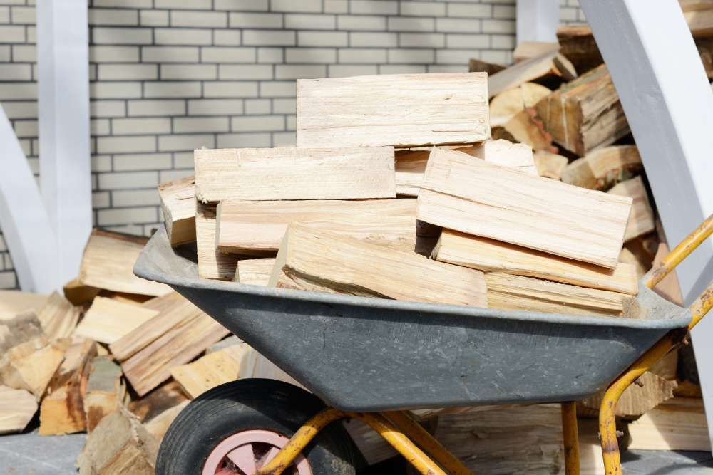 A Wheelbarrow Filled With Wood Is Sitting Next To A Pile Of Wood — HKL Landscape Supplies in Nabiac, NSW 