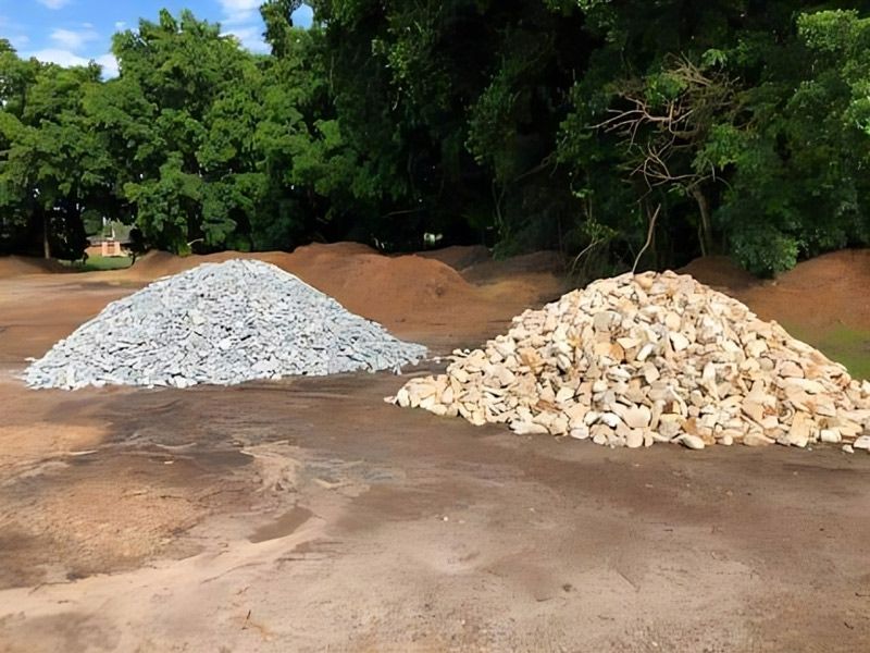 Two Large Pile Of Gravel Sitting In A Field — HKL Landscape Supplies in Taree, NSW 