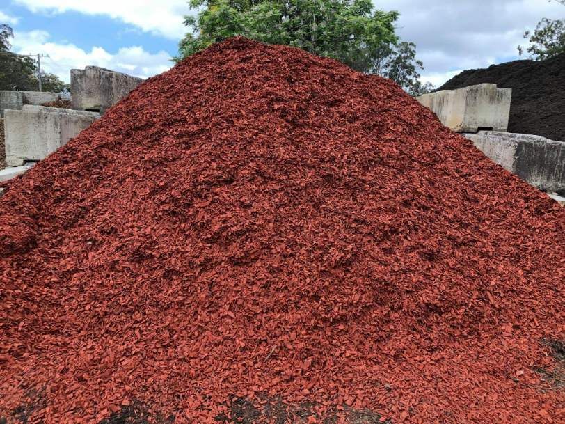 A Pile of Red Mulch is Sitting on Top of a Pile of Concrete Blocks — HKL Landscape Supplies in Tuncurry, NSW