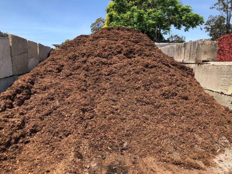A Large Pile Of Dirt Is Sitting On Top Of A Concrete Wall — HKL Landscape Supplies in Taree South, NSW