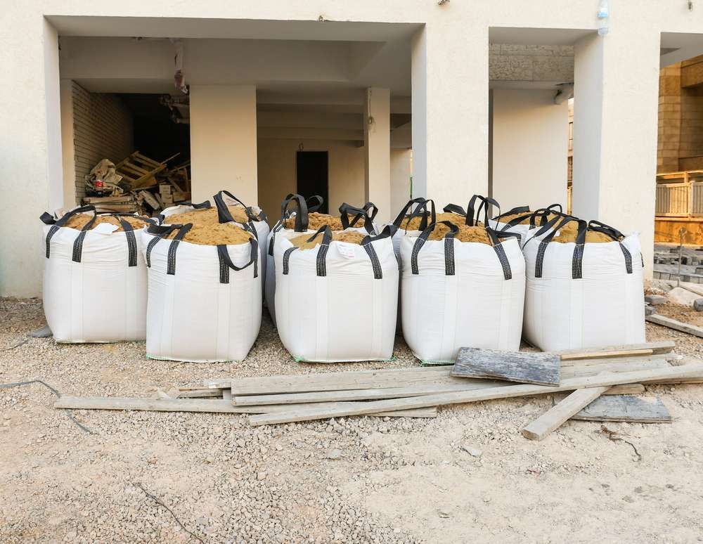 A Row Of White Bags Are Lined Up In Front Of A Building Under Construction — HKL Landscape Supplies in Gloucester, NSW 