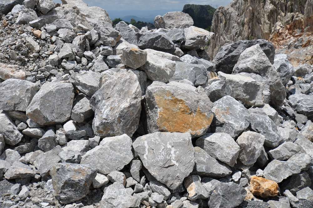 A Pile Of Rocks In A Quarry With A Mountain In The Background — HKL Landscape Supplies in Tuncurry, NSW 
