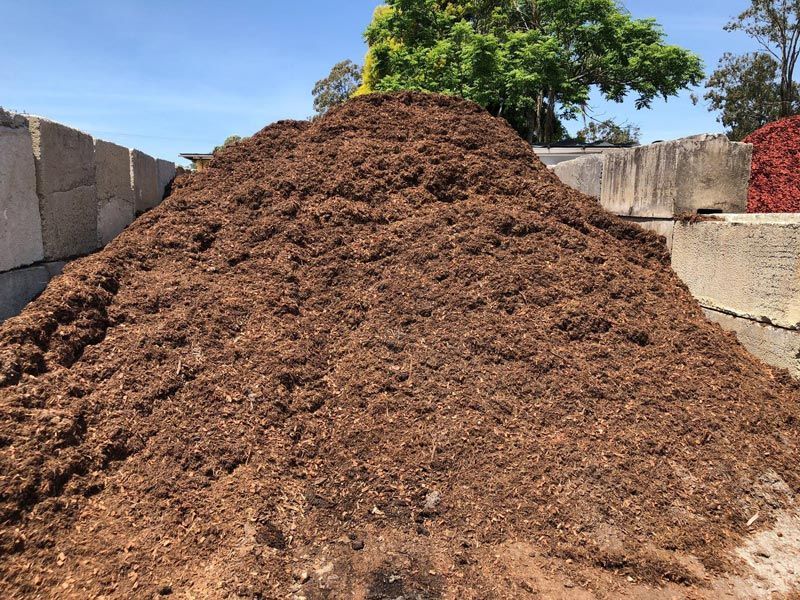 A Pile of Brown Dirt is Sitting on Top of a Concrete Block — HKL Landscape Supplies in Old Bar, NSW
