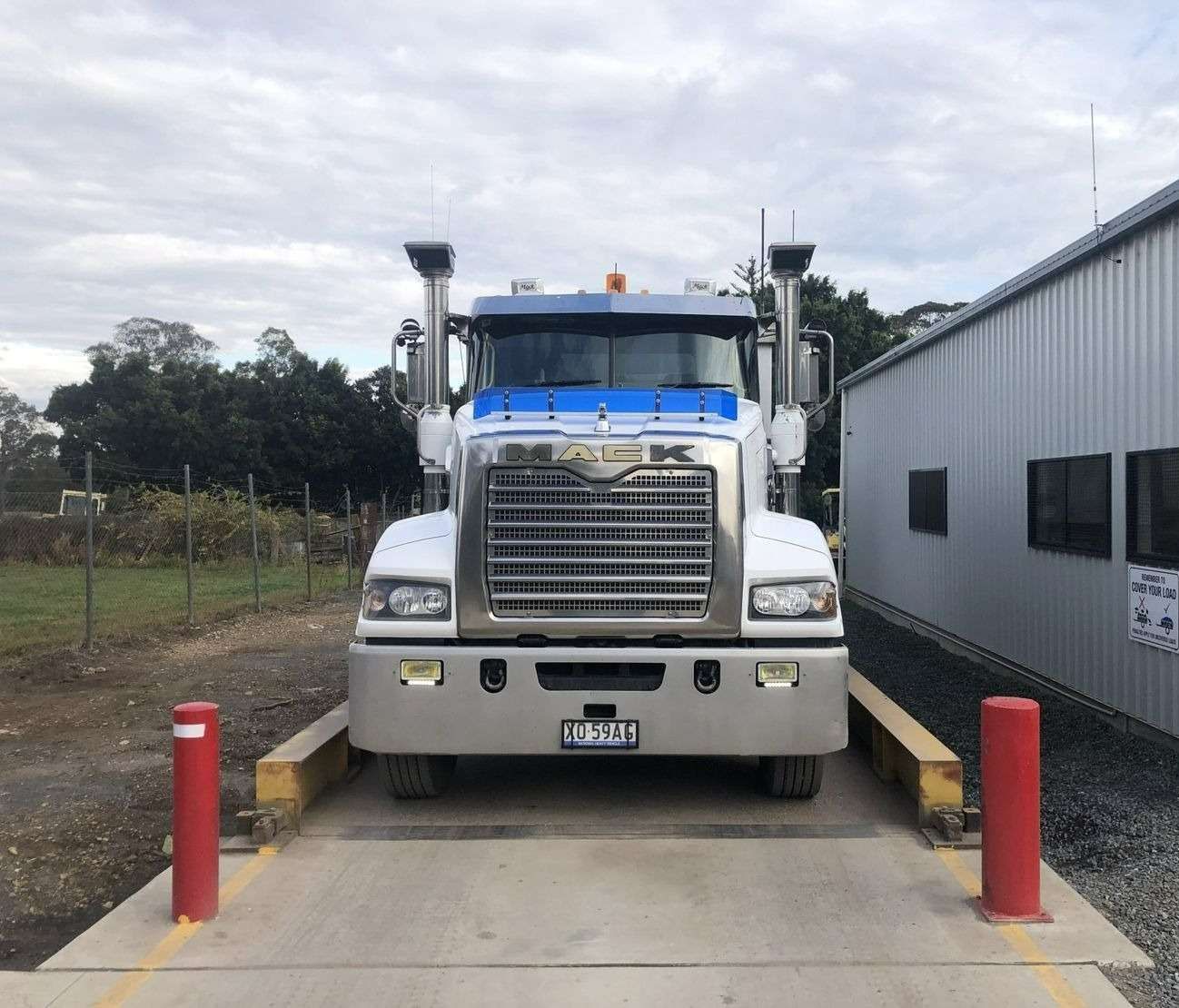 A Mack Truck Is Sitting On A Scale In Front Of A Building — HKL Landscape Supplies in Taree South, NSW