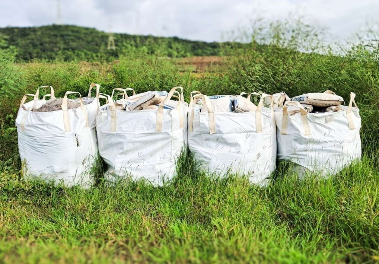 A Row Of Bags Sitting On Top Of A Lush Green Field — HKL Landscape Supplies in Taree South, NSW