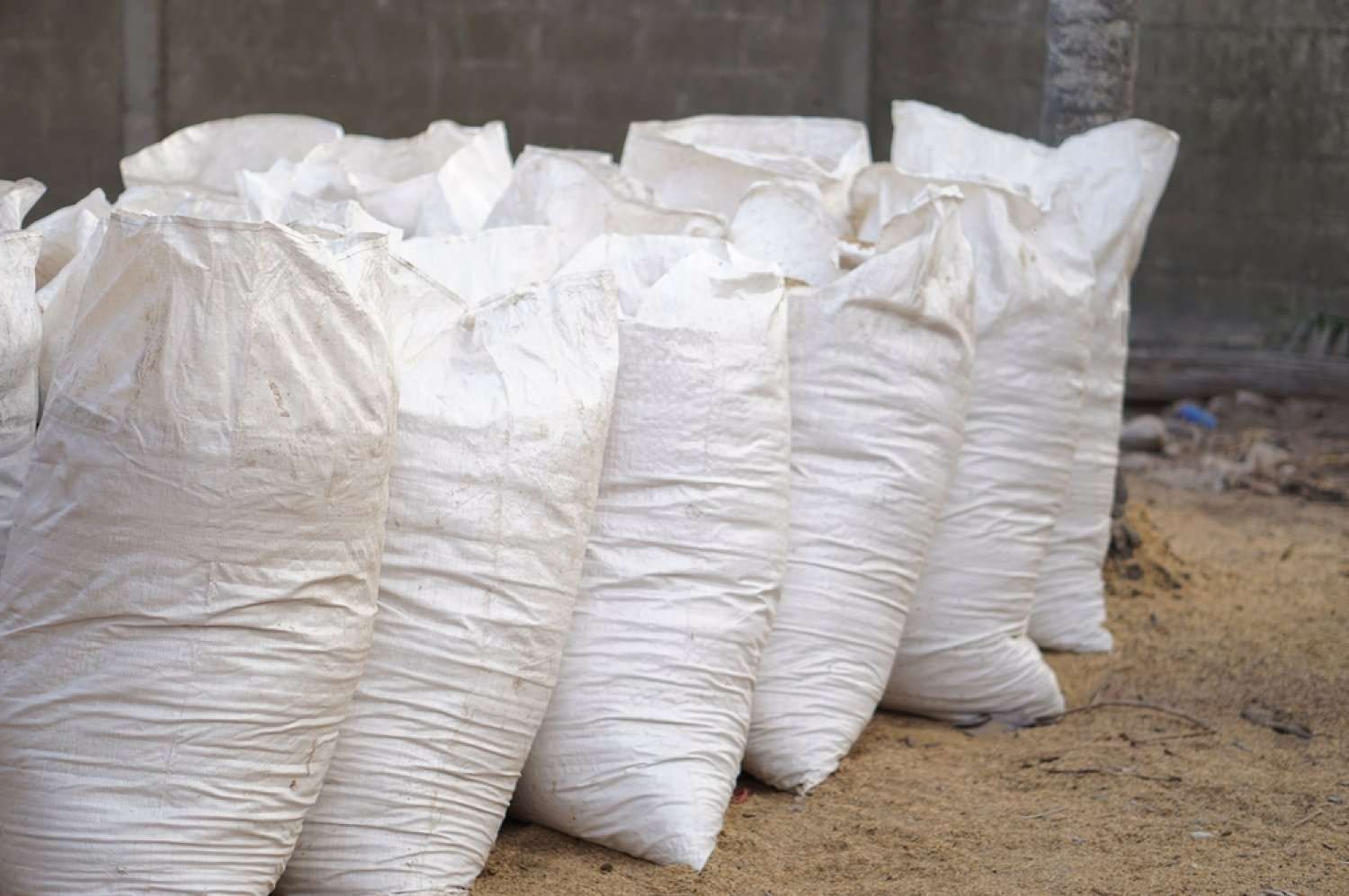 A Bunch Of White Bags Sitting On Top Of A Pile Of Sand — HKL Landscape Supplies in Nabiac, NSW 