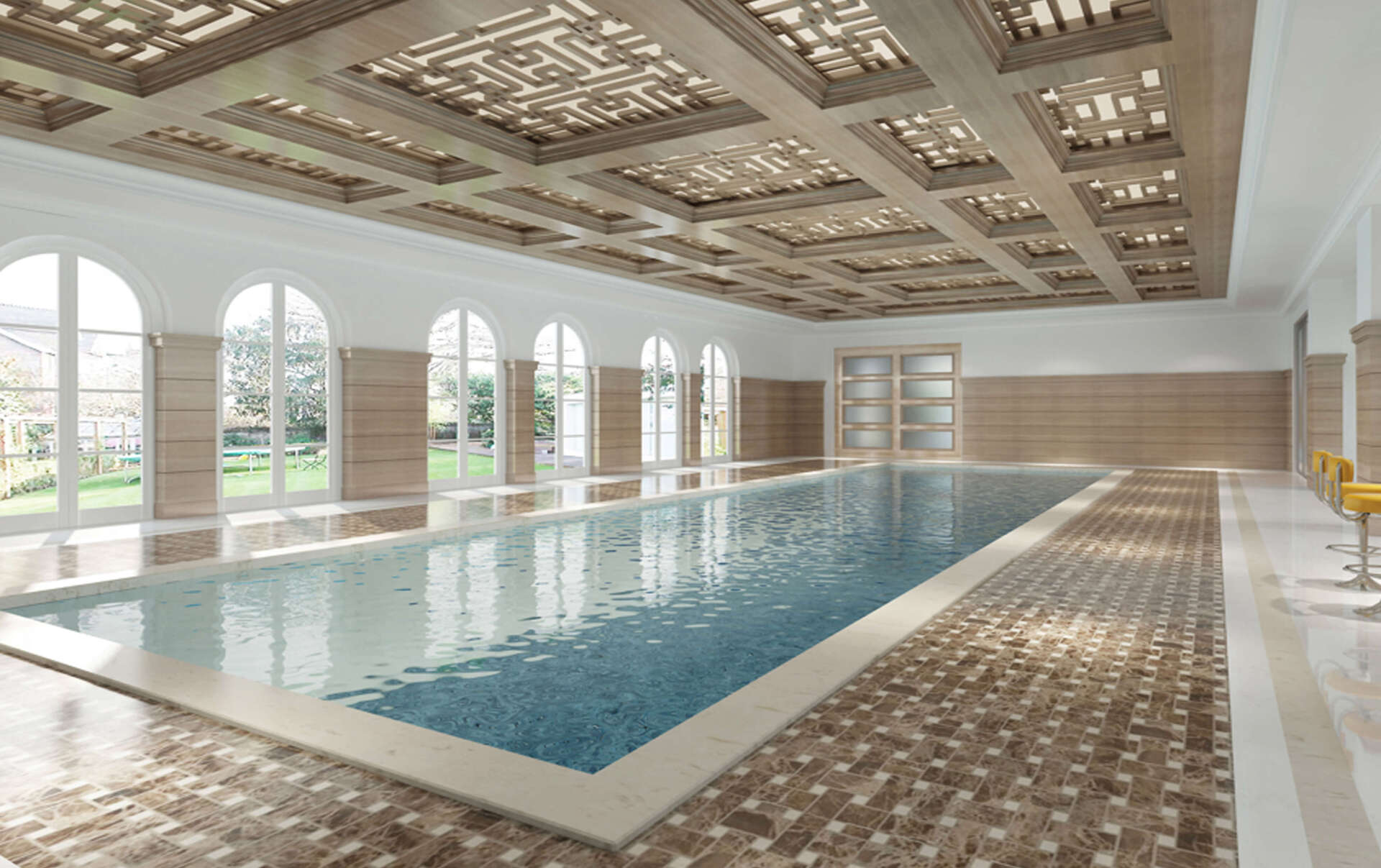 Indoor swimming pool with patterned ceiling and tiled floor. Large windows overlook a grassy area.