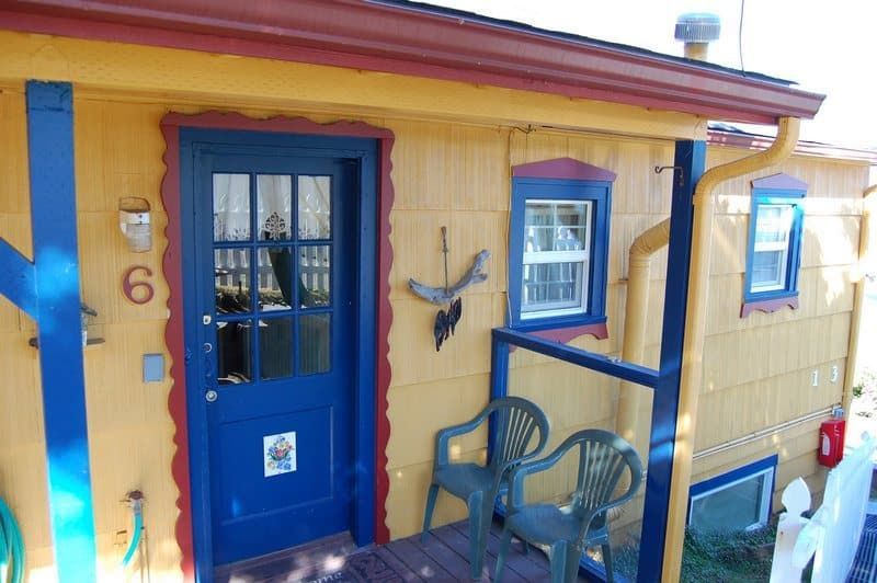 A yellow house with a blue door and the number 6 on it