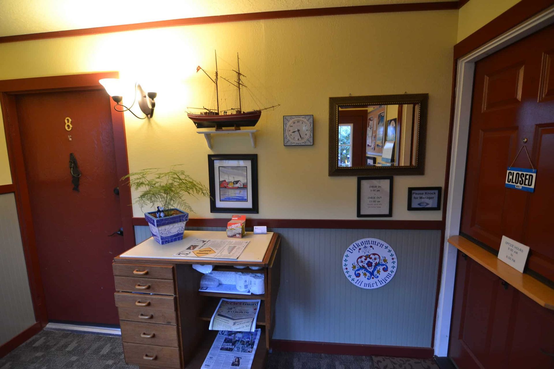 A hallway with a desk and a ship on the wall