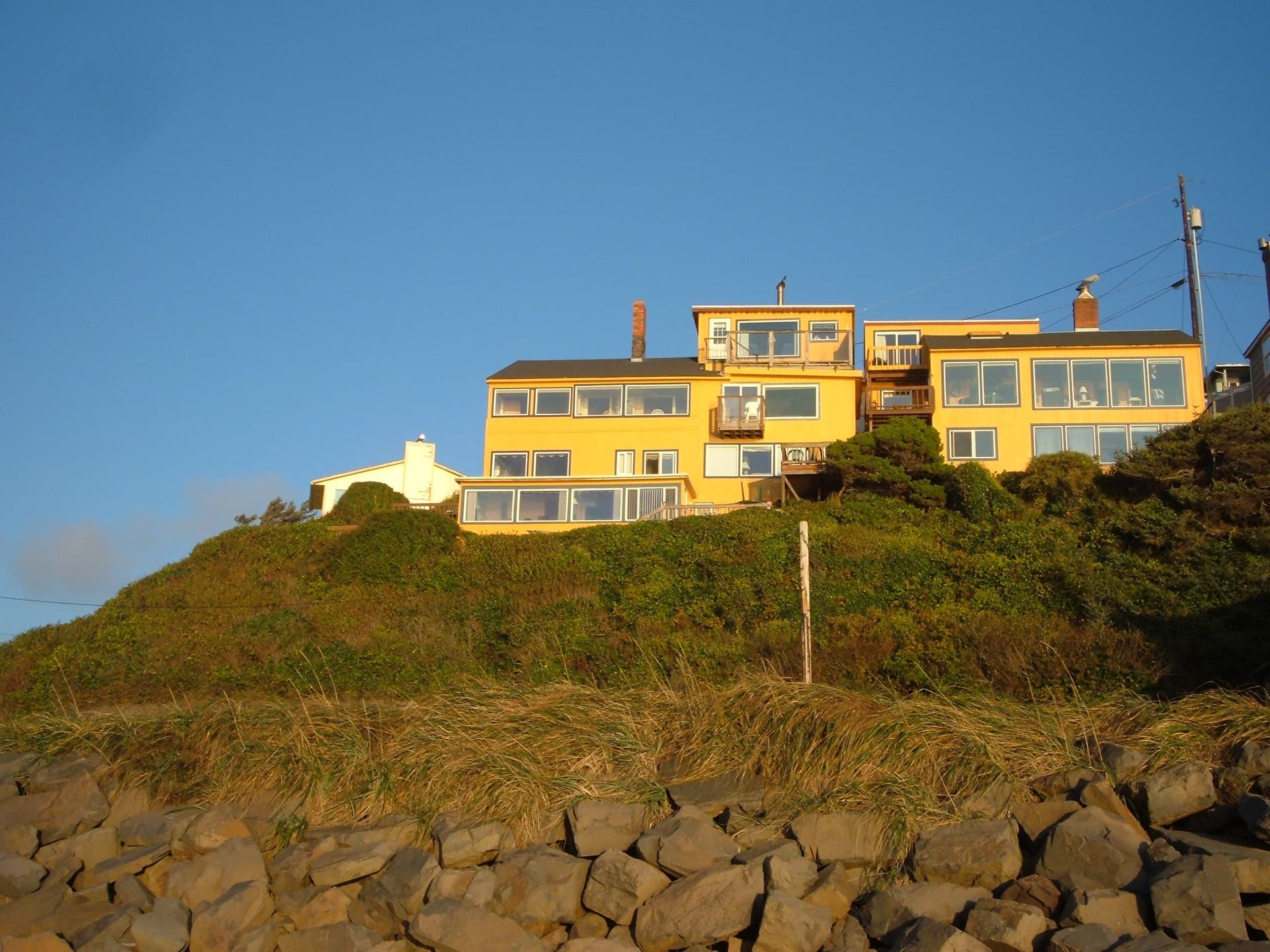A large yellow house sits on top of a hill