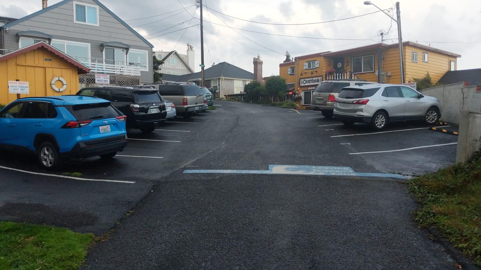 A parking lot with cars parked on the side of the road.
