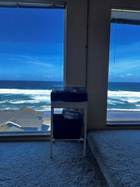 A room with a large window looking out to the ocean