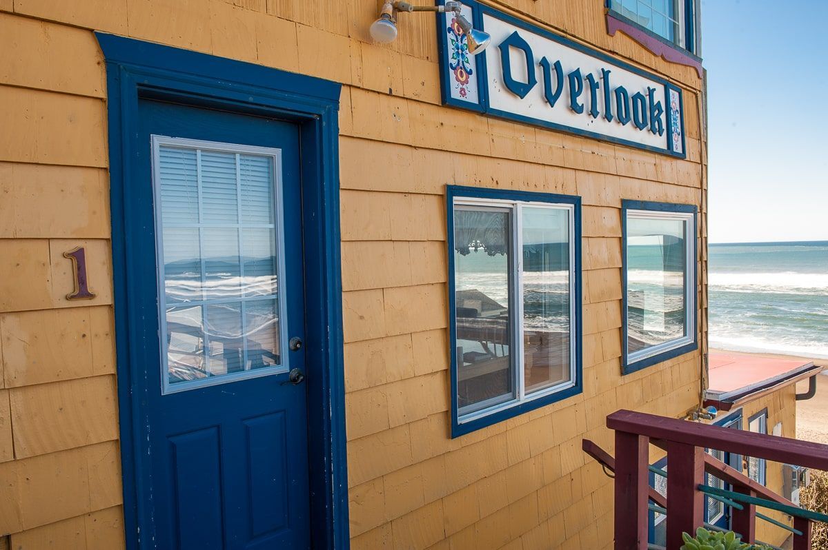A yellow building with a blue door and a sign that says overlook