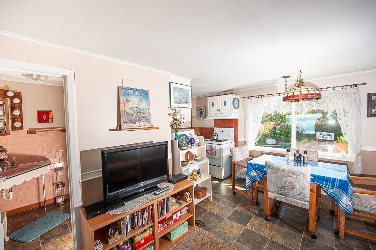 A living room with a table , chairs and a television.