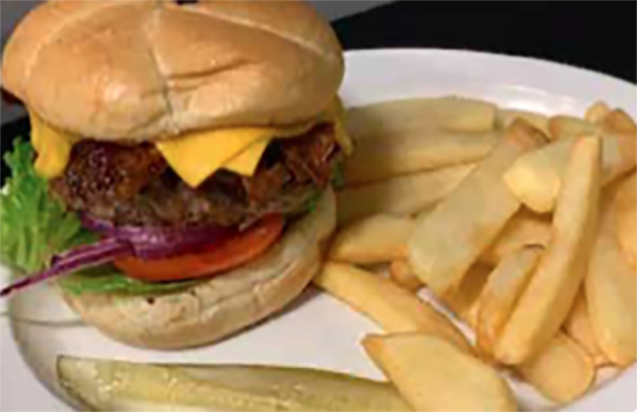 Cheeseburger with fries and pickle on a plate.