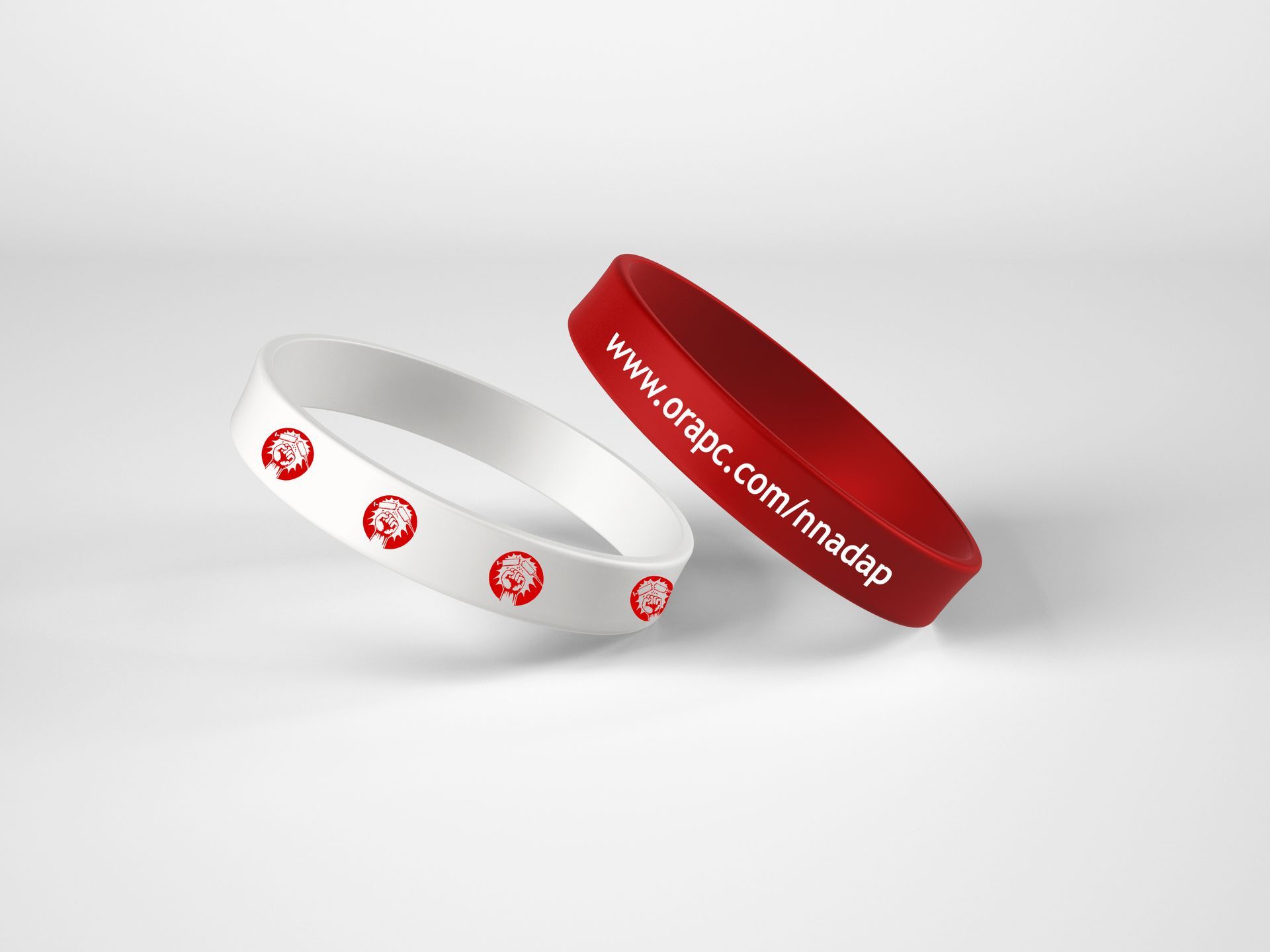Two red and white bracelets are sitting on a white surface.