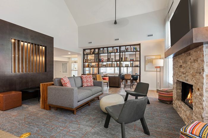 A living room with a couch , chairs , and a fireplace.