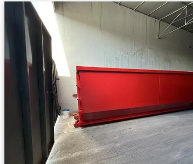 A red dumpster in a building.