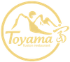 Logo dorato del ristorante Toyama Fusion con montagne stilizzate e bordo circolare.