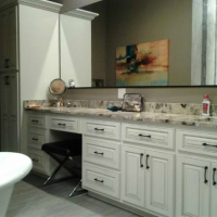 Modern bathroom vanity with white cabinets, marble countertop, sink, mirror, and wall art
