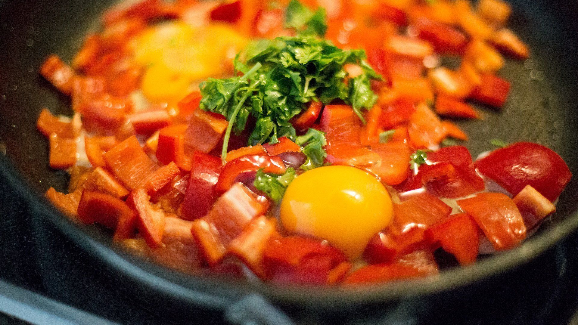 A frying pan filled with vegetables and an egg.