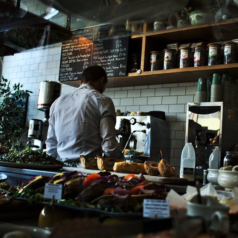 A man standing behind a counter in a restaurant making food