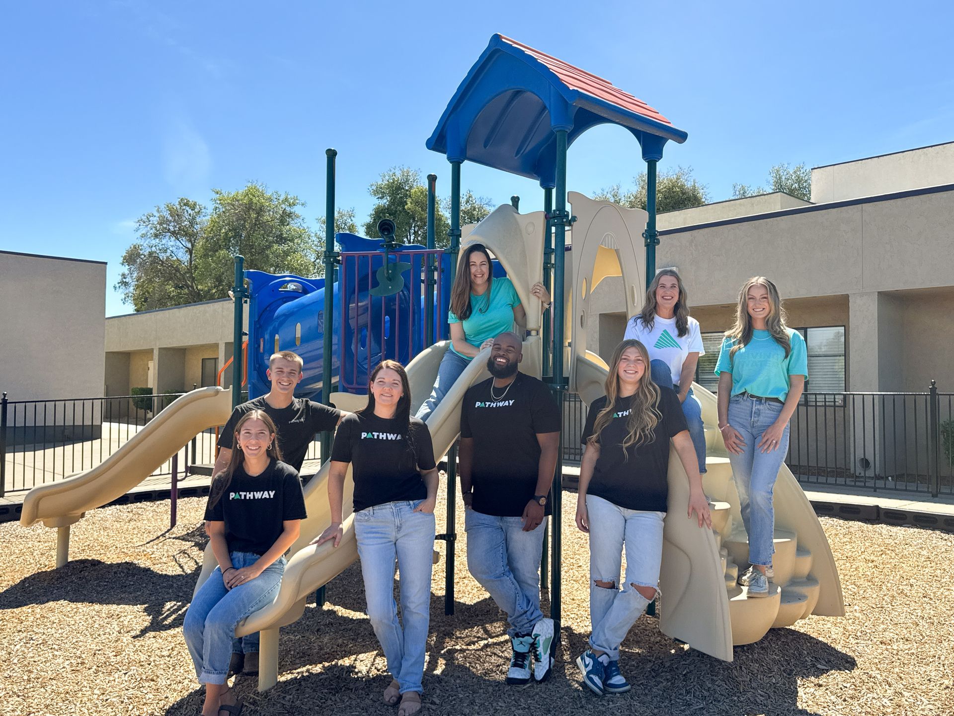 group of adults posed by a playground