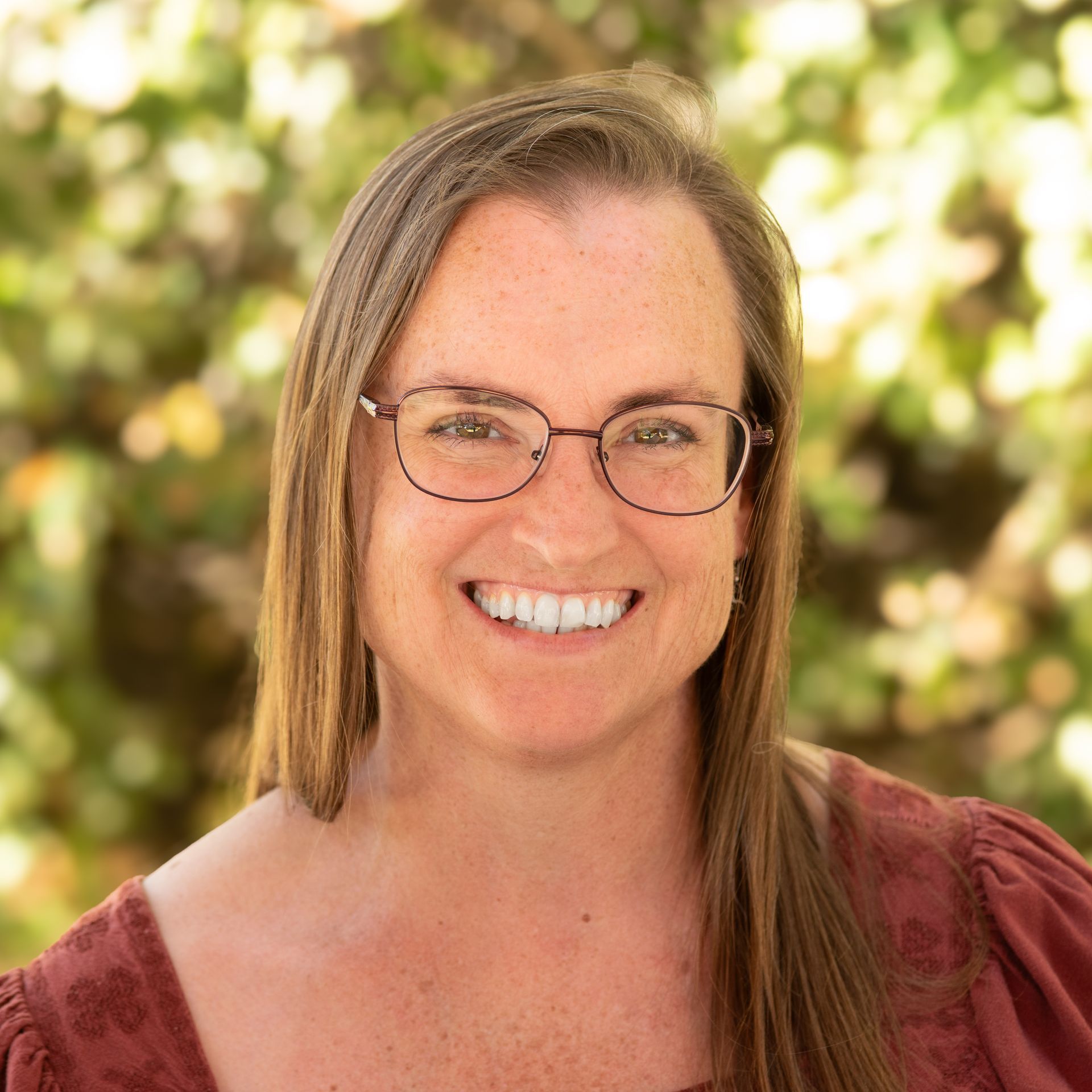 image of woman, wearing glasses, smiling