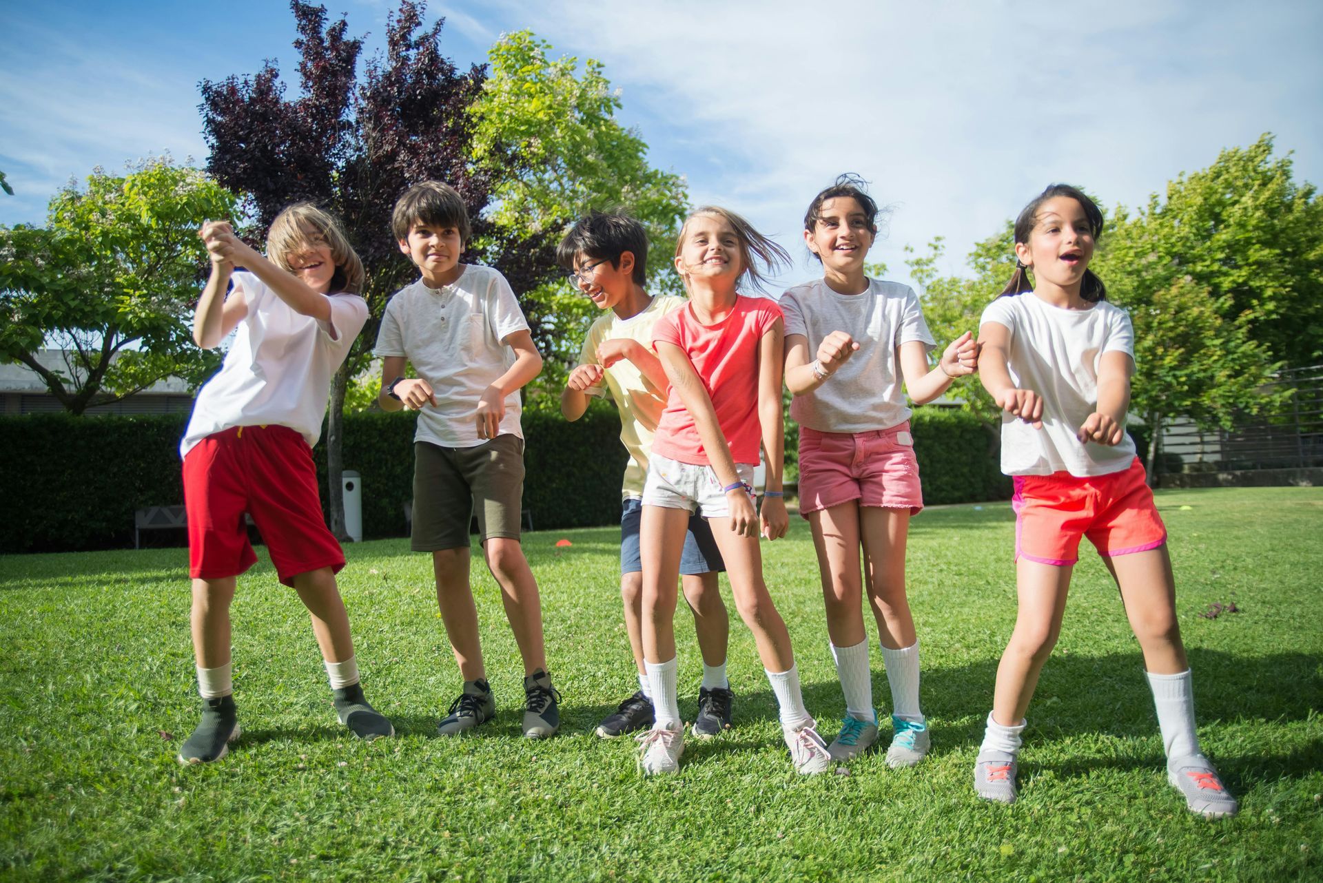 group of smiling kids standing on the lawn