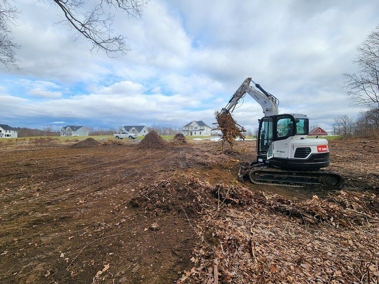 A bulldozer is digging a hole in a dirt field.