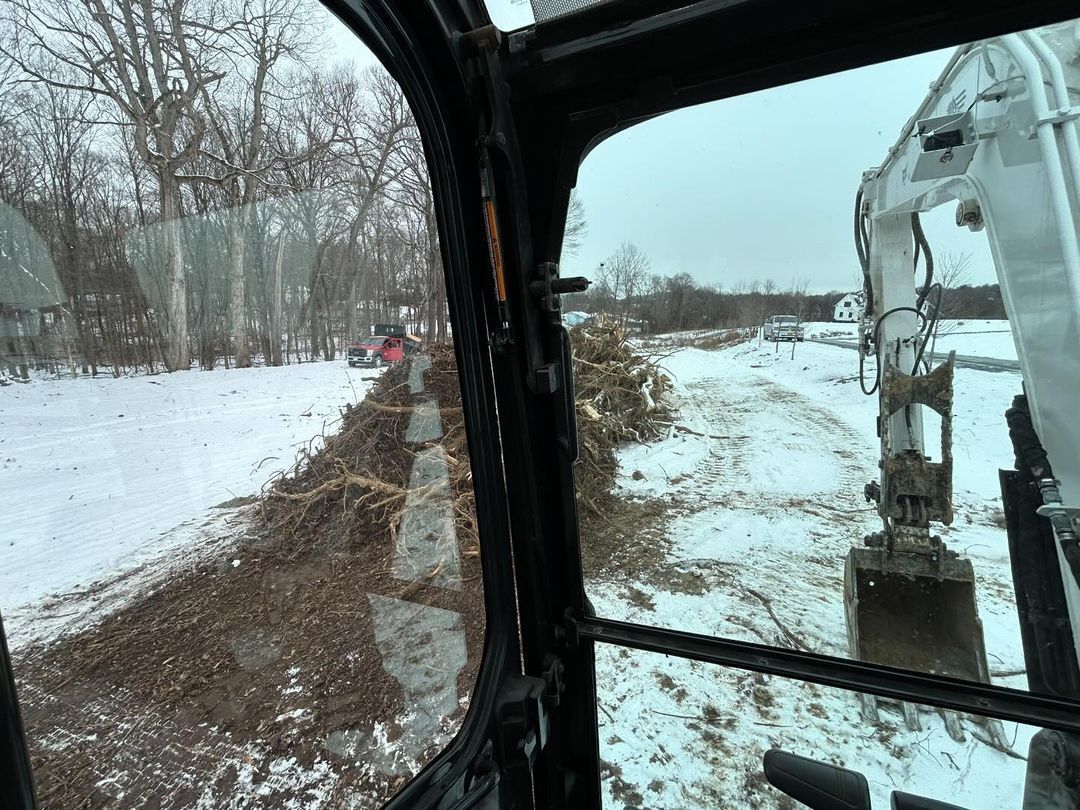 A person is driving a bulldozer on a snowy road.