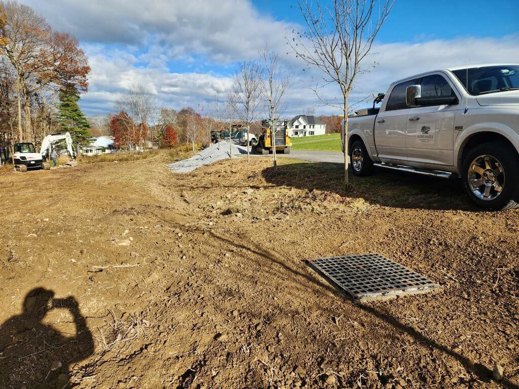 A white truck is parked in a dirt field.