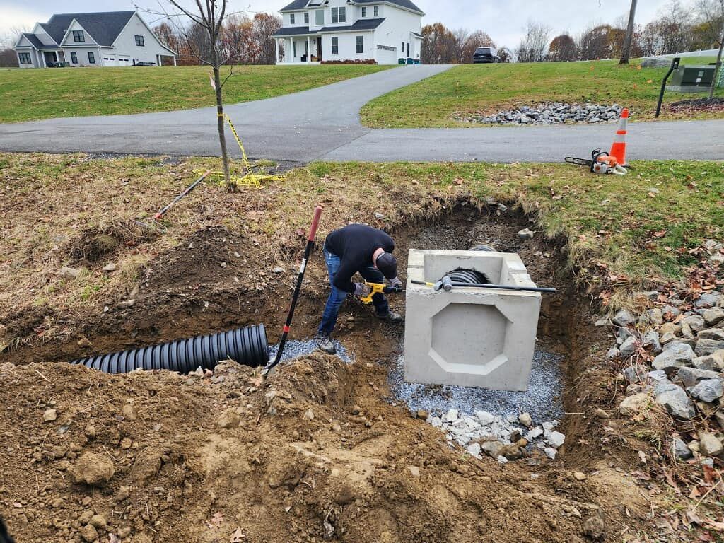 A man is digging a hole in the dirt in front of a house.