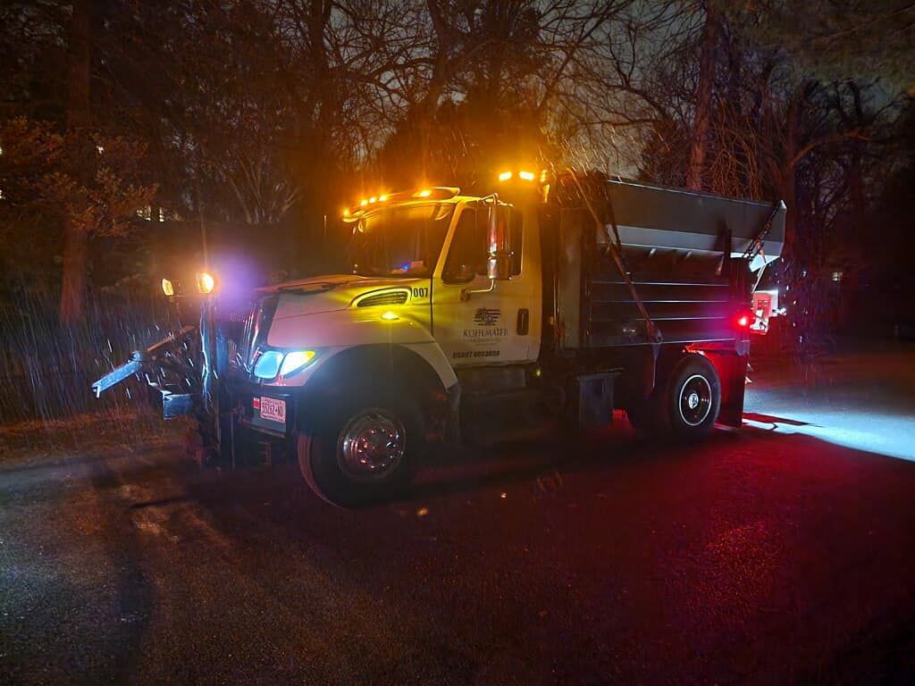 A truck is parked on the side of the road at night.