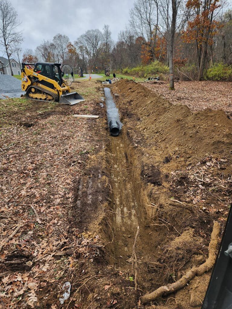 A yellow bulldozer is digging a trench in a field.