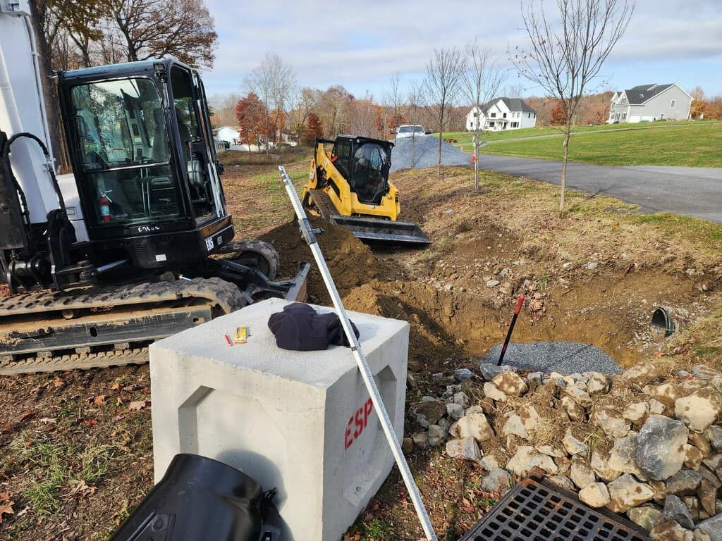 A bulldozer is digging a hole in the ground next to a concrete block.