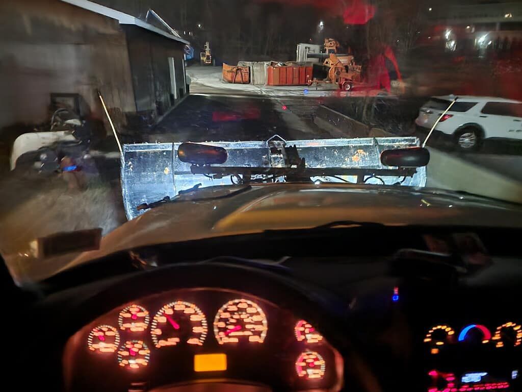 A car is parked in a parking lot at night.