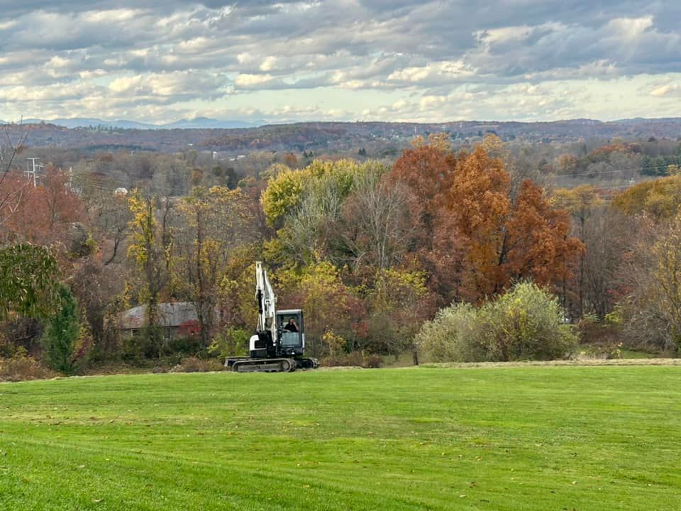 A bulldozer is sitting in the middle of a lush green field.
