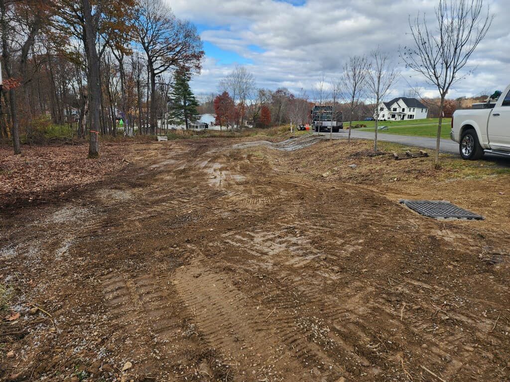 A white truck is parked on the side of a dirt road.