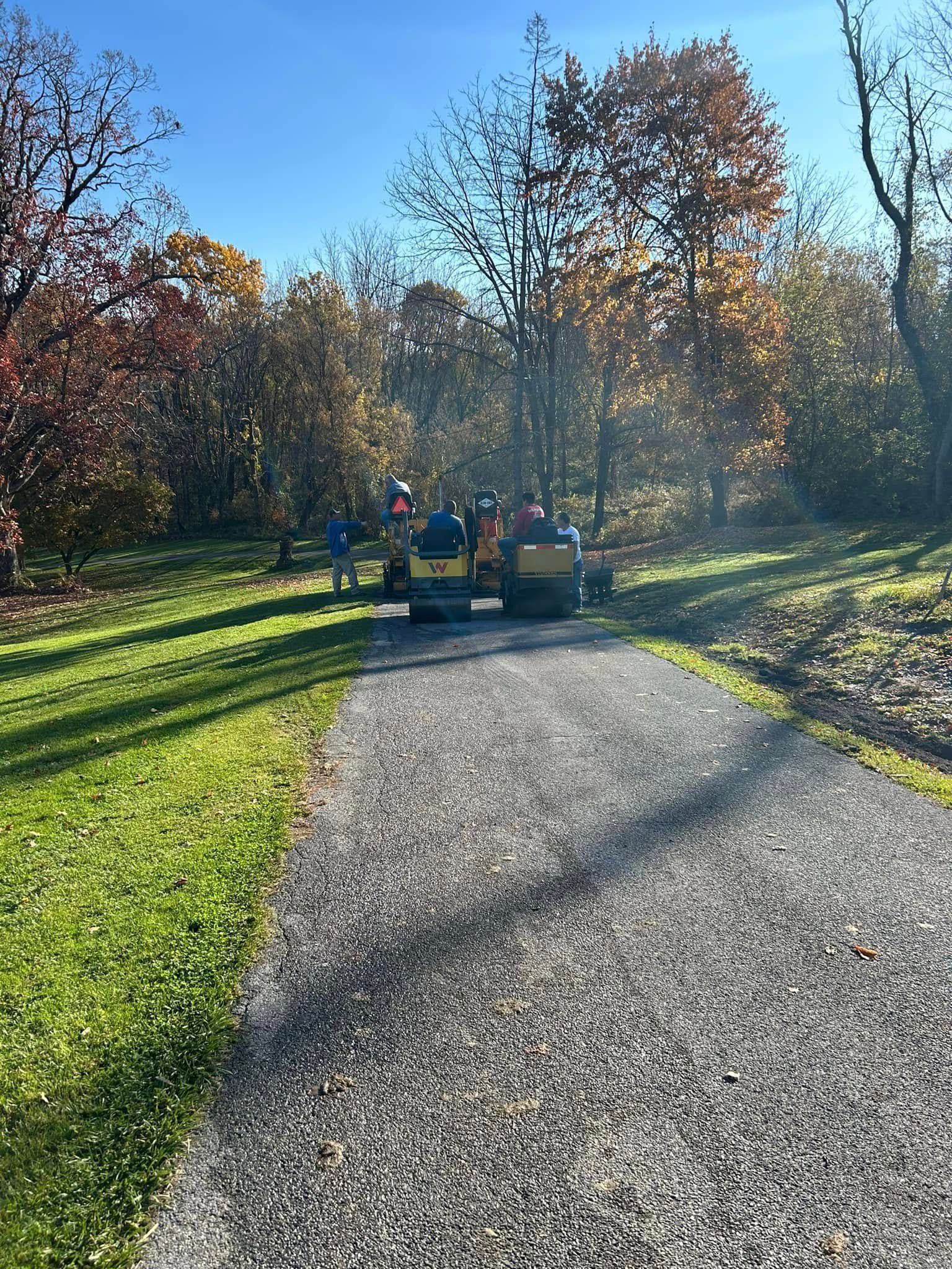 A group of people are riding a tractor down a gravel road.