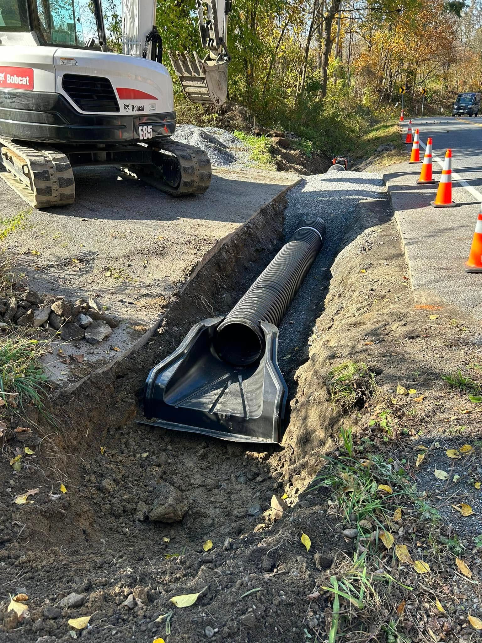 A bulldozer is digging a trench next to a road.