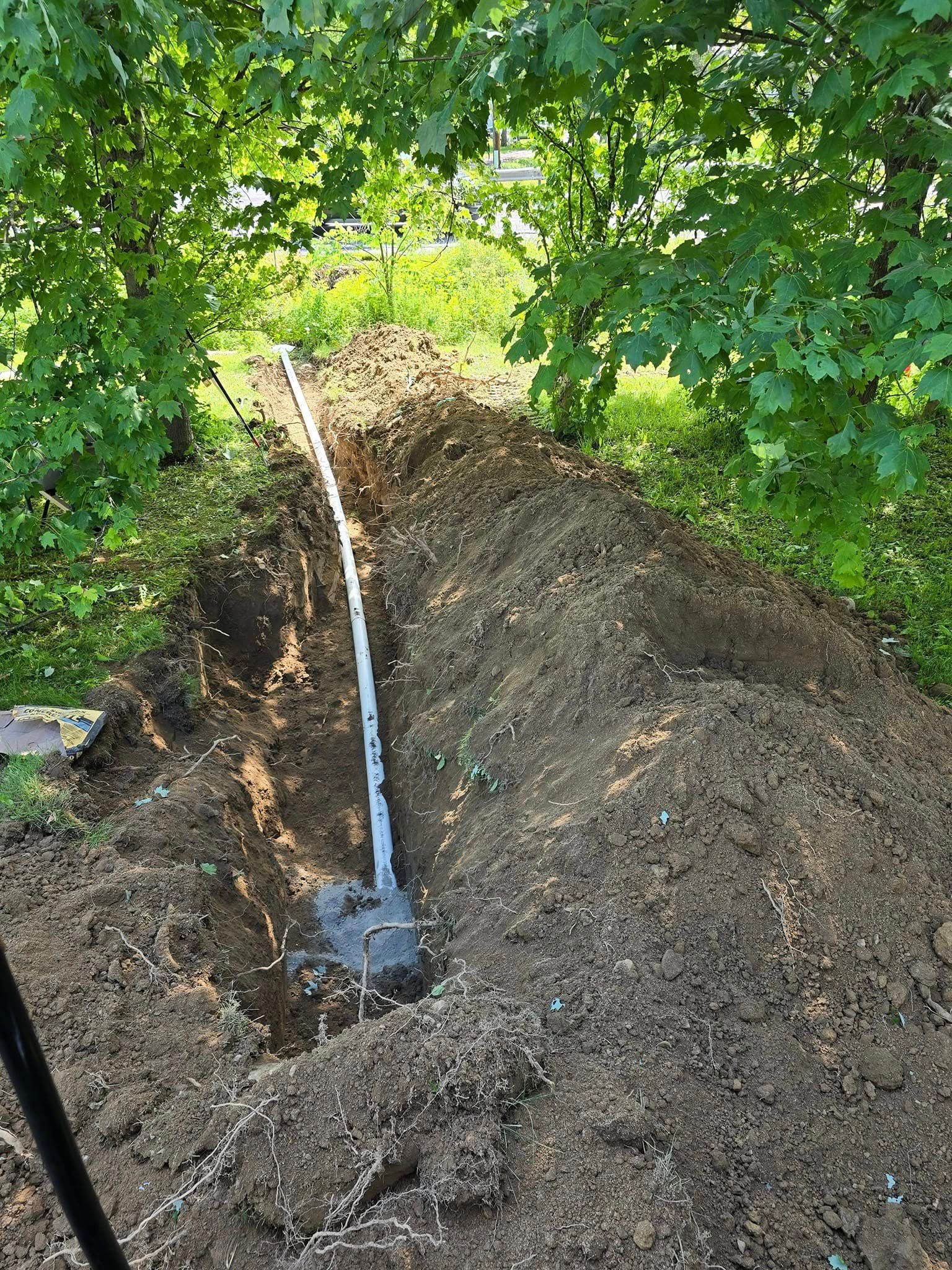 A pipe is being installed in a hole in the ground.