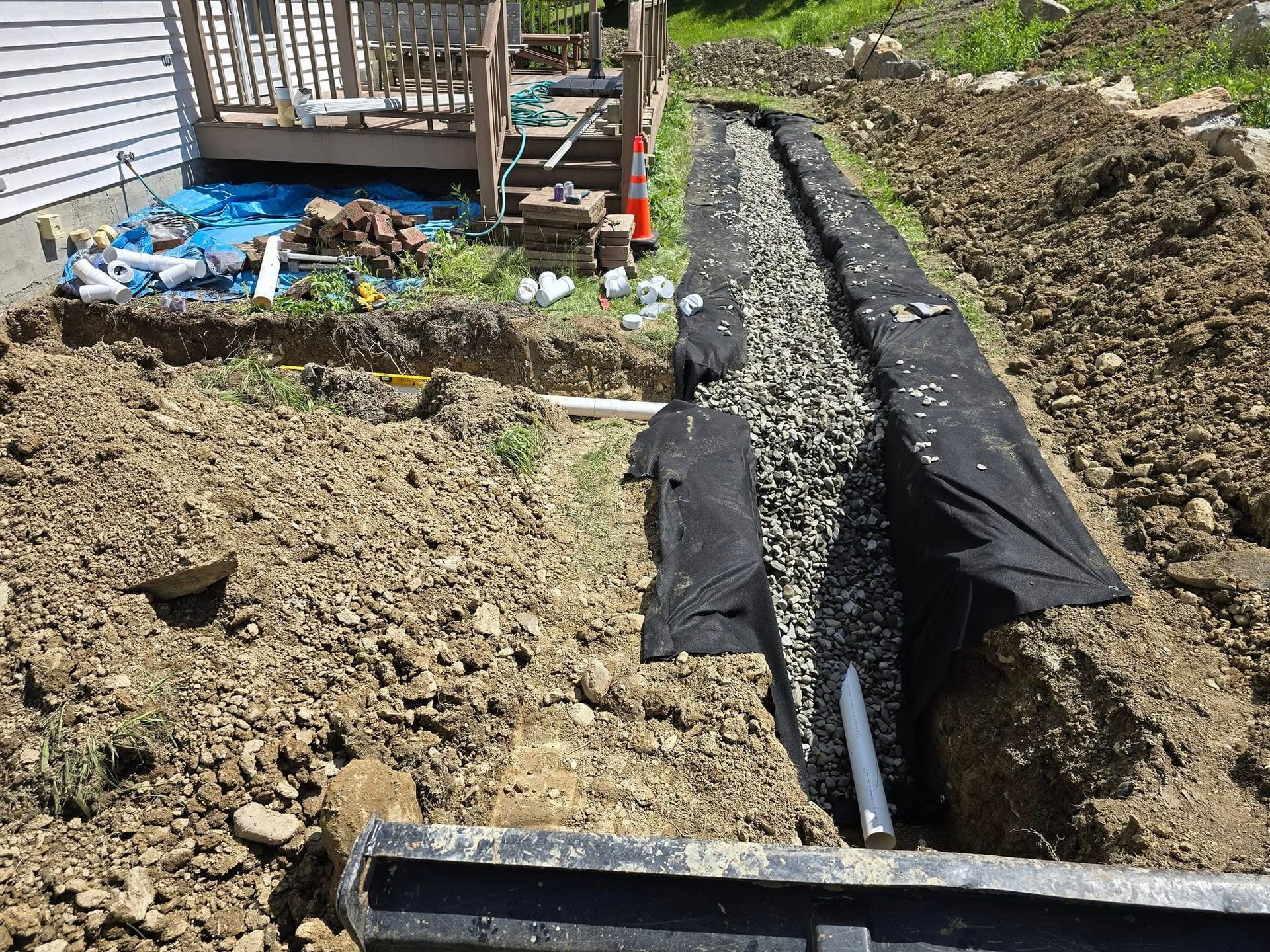 A drainage system is being installed on the side of a house.