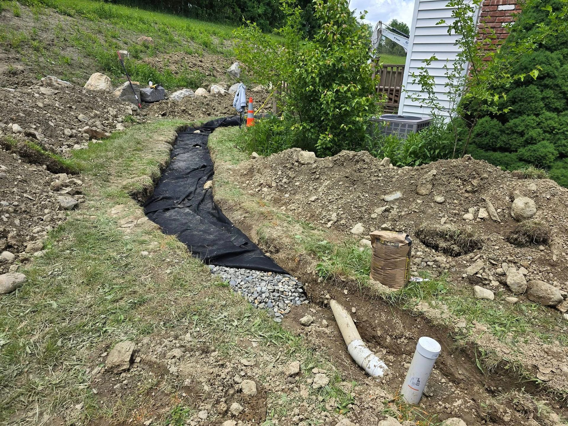 A drainage system is being installed in the backyard of a house.