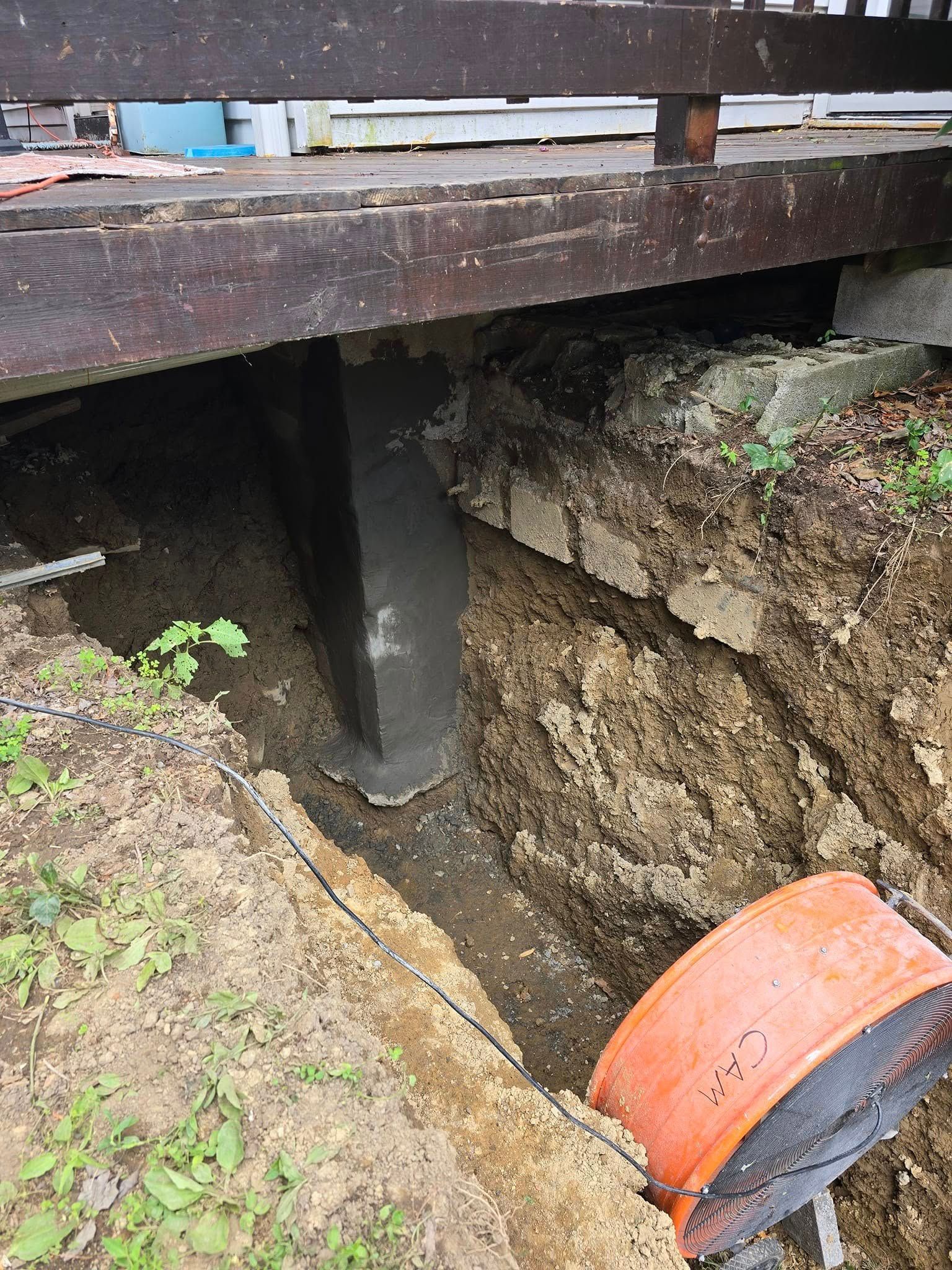 A drain pipe is being installed in a hole in the ground.