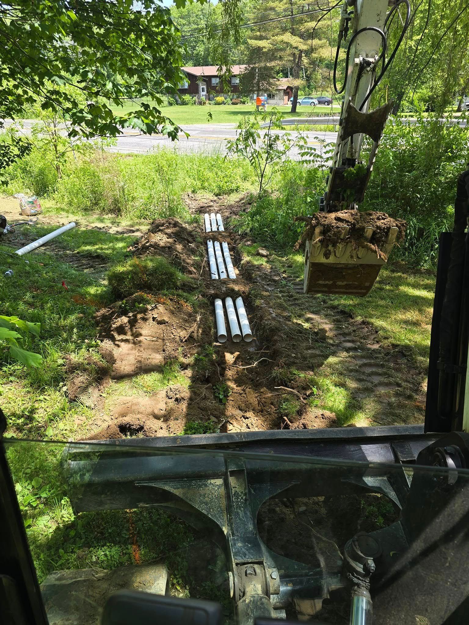 A person is driving a tractor through a dirt field.