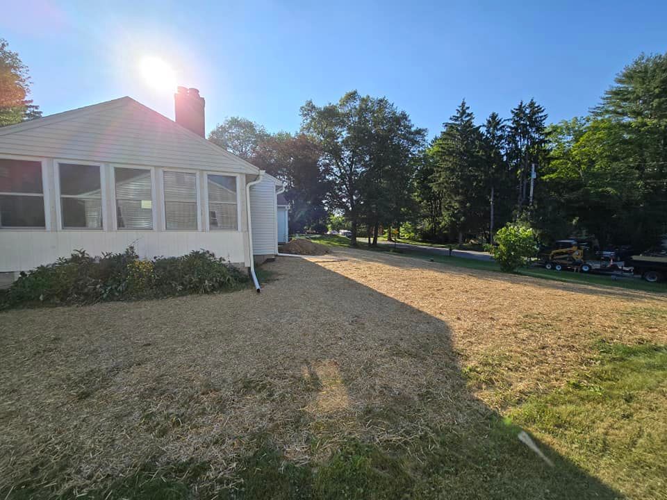 A white house with a gravel driveway in front of it.